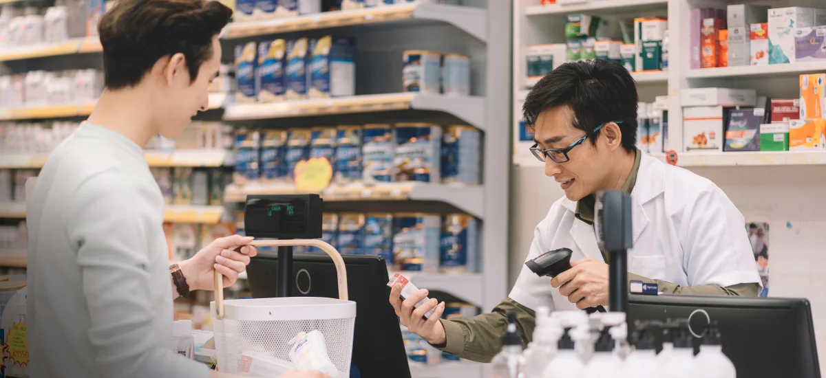 A pharmacist scanning a product at the counter